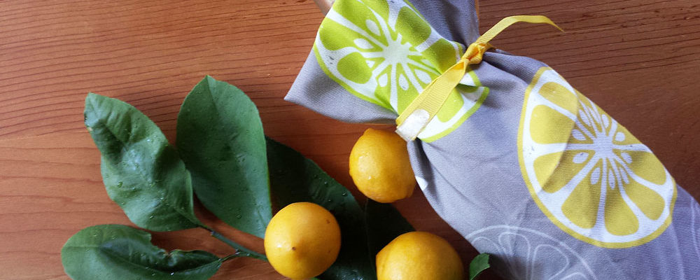 Bottle gift wrapped with Orange, Orange, Lemon, Lime tea towel by Lellobird